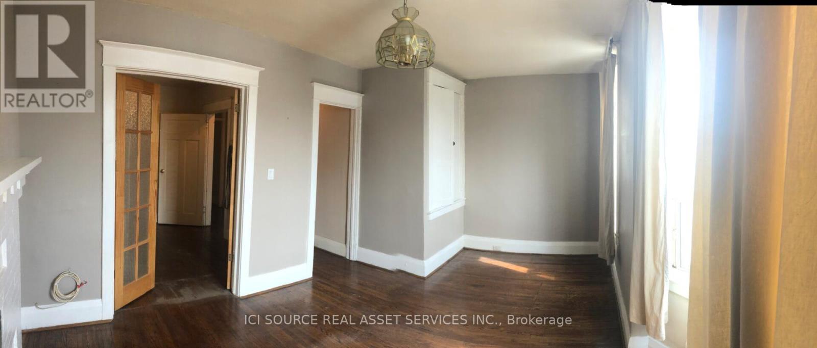 A room with a chandelier and a doorway leading to another room.