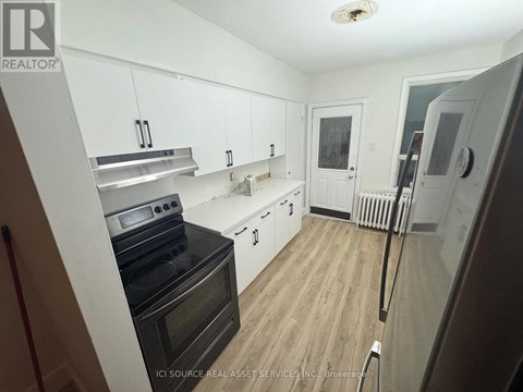 A kitchen with white cabinets and a black stove top oven.