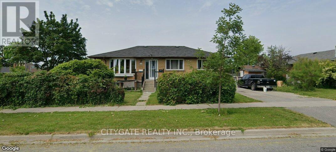 A house with a front yard and a tree in front of it.