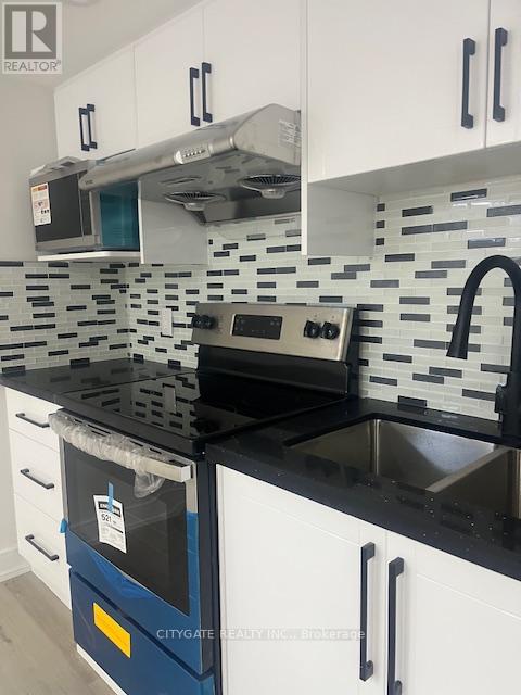 A kitchen with black countertops and white cabinets.