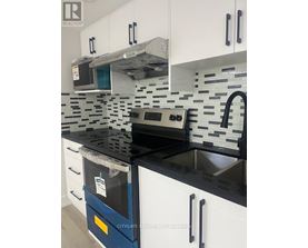 A kitchen with black countertops and white cabinets.
