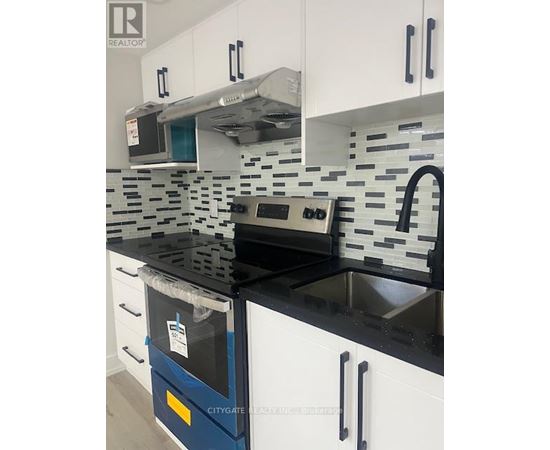 A kitchen with black countertops and white cabinets.