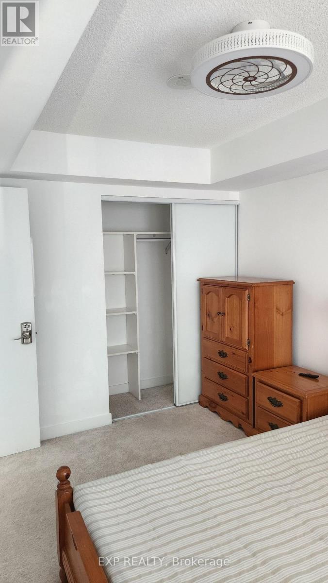 A bedroom with a bed, dresser, and wardrobe.