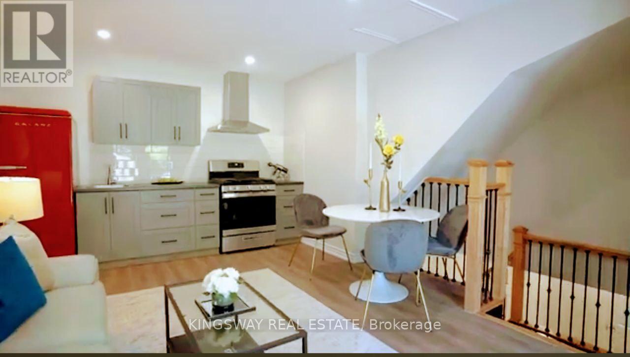 A modern kitchen with a dining area and a staircase.