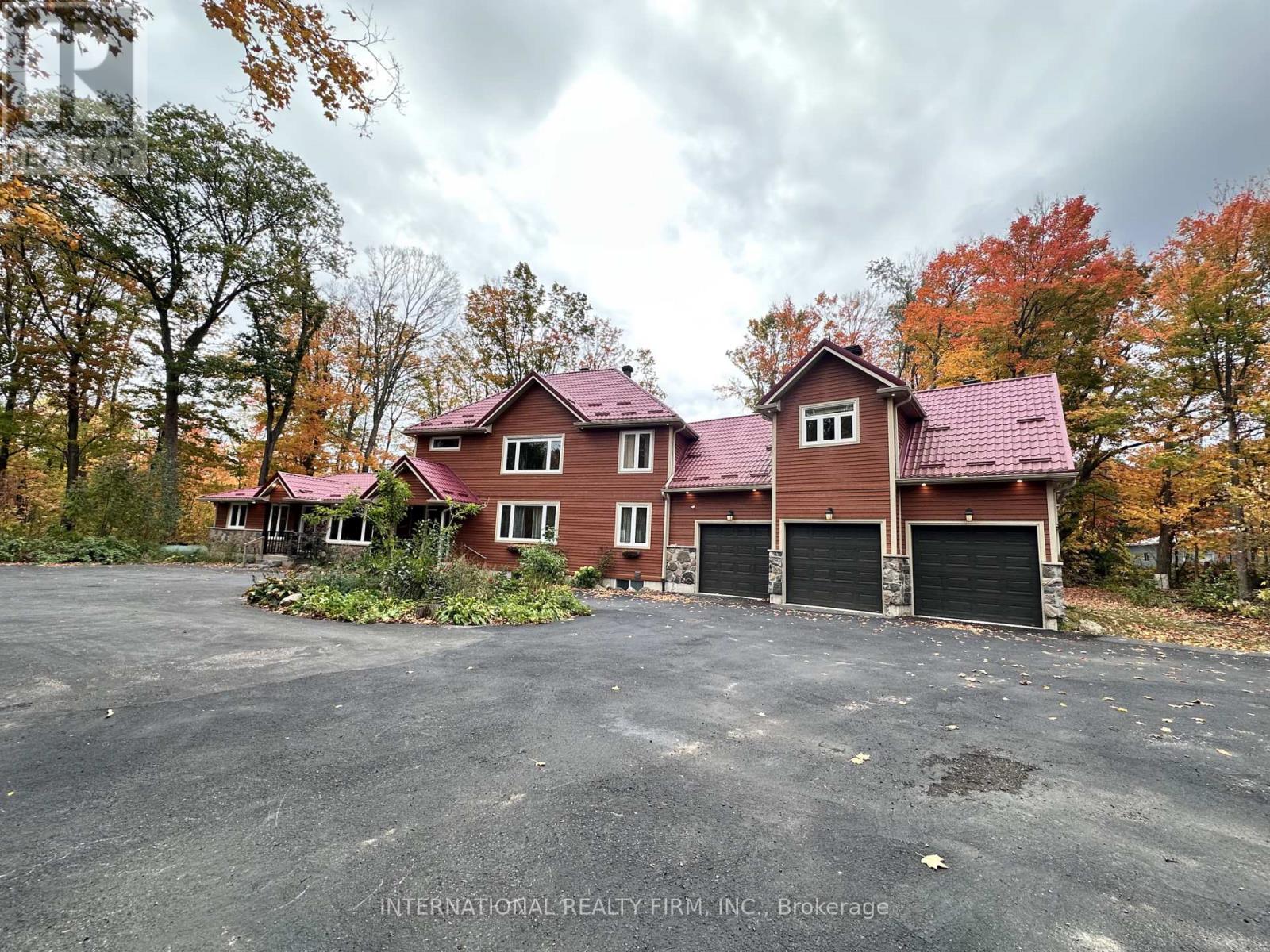 A house with a red roof and a parking lot in front.