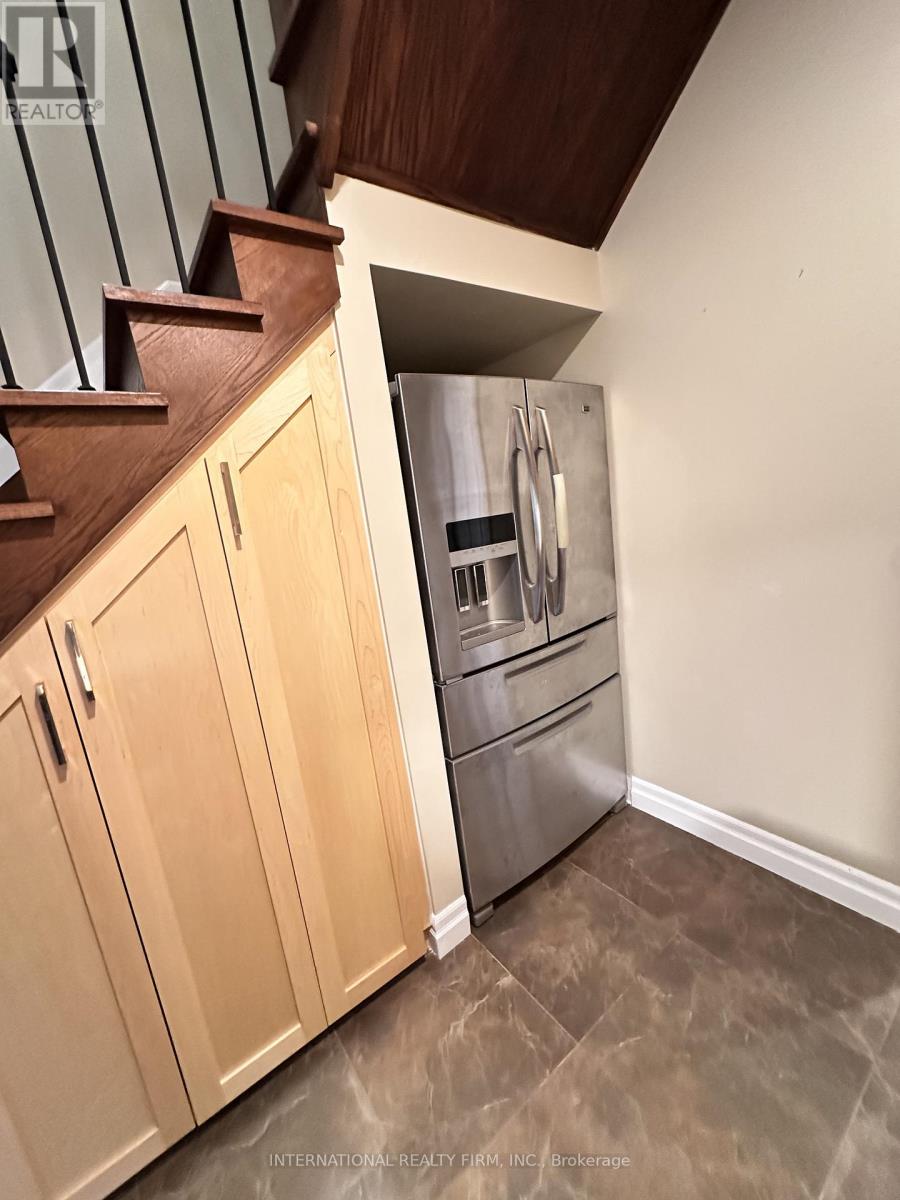 A kitchen with wooden cabinets and a stainless steel refrigerator.