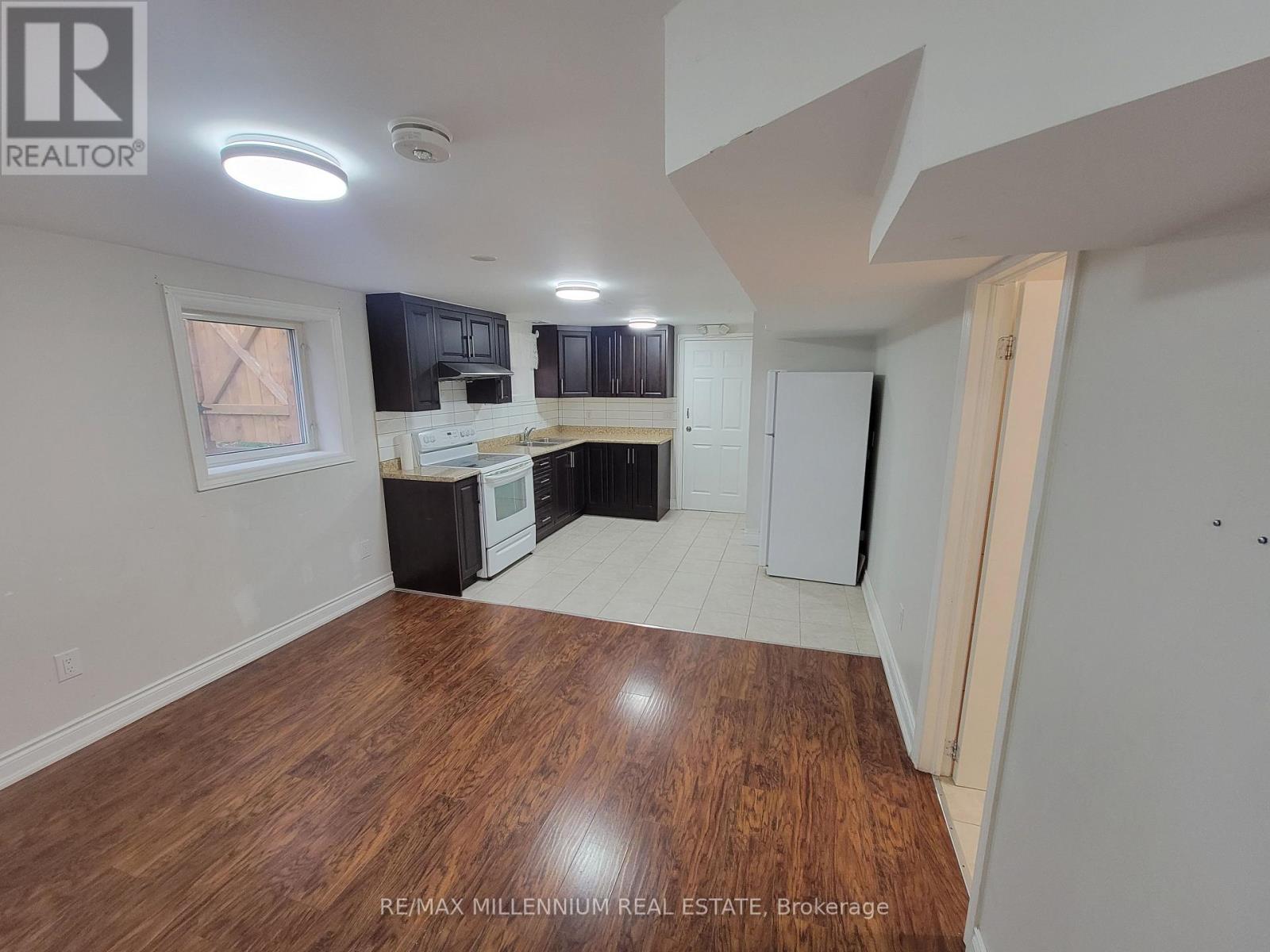 A kitchen with white appliances and wooden floors.