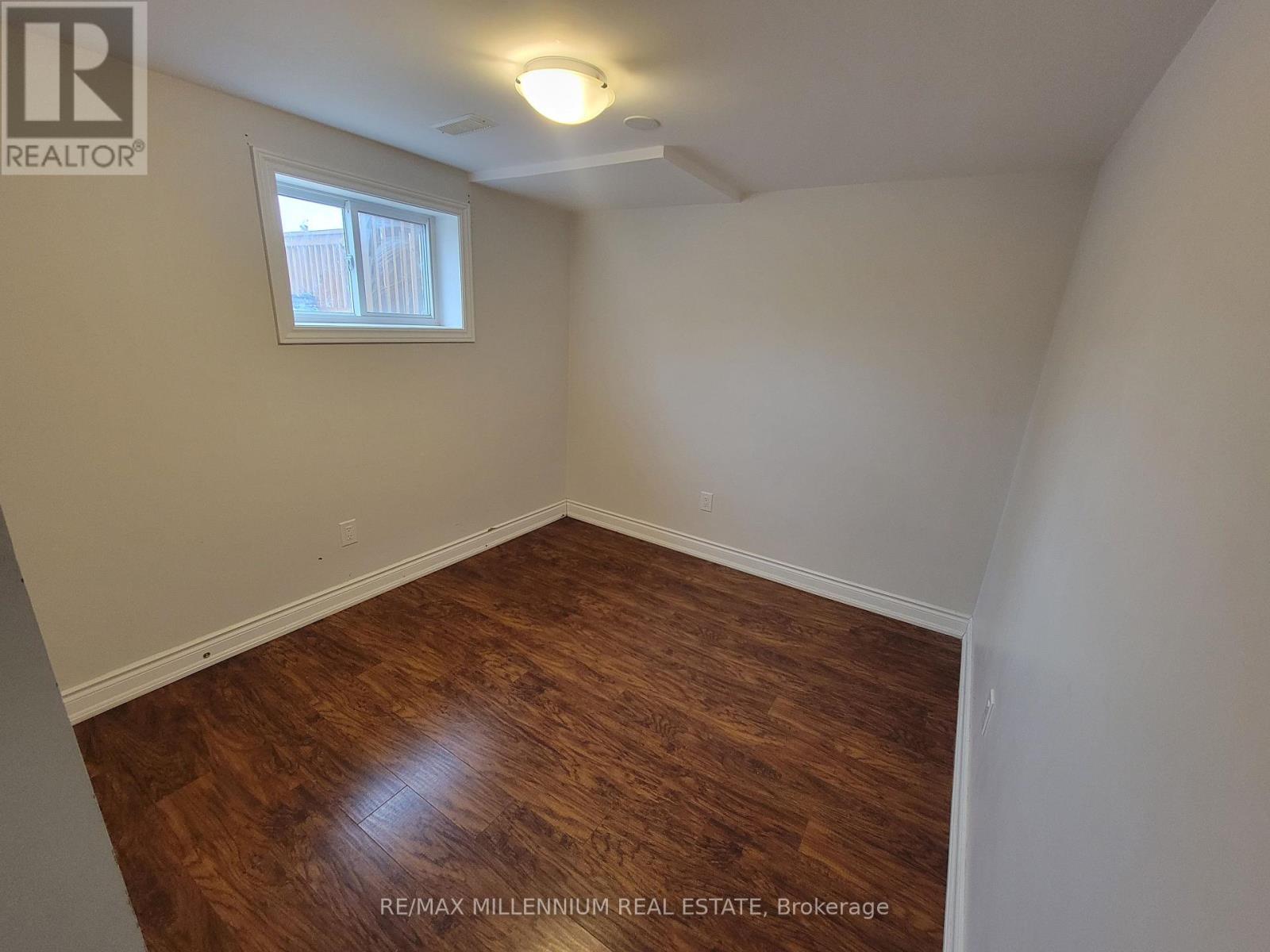 A room with a window and wooden flooring.