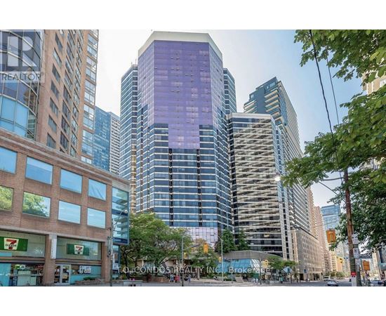 A tall building with a purple tinted glass facade stands in front of other buildings.