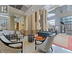 A large, modern lounge area with patterned chairs and a piano.