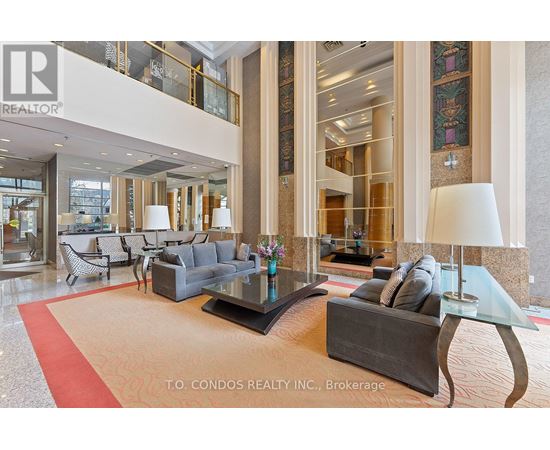 A large, modern living room with a glass table and a red carpet.