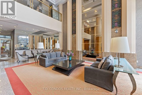 A large, modern living room with a glass table and a red carpet.