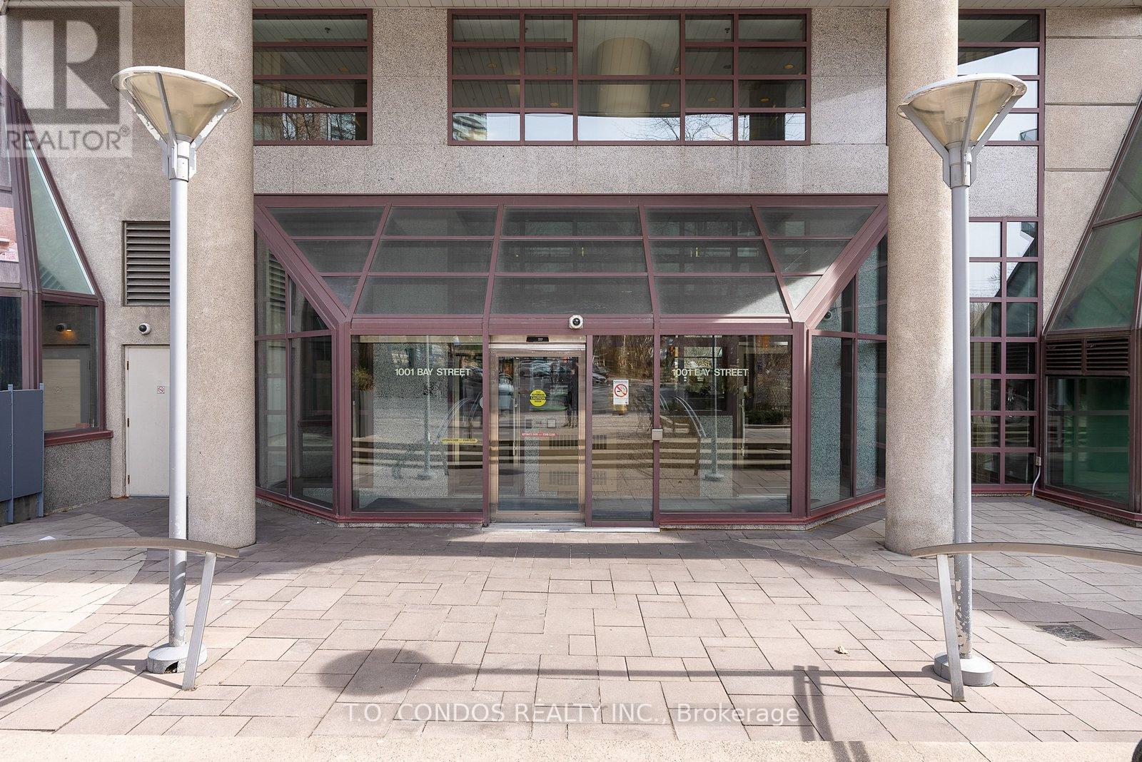 A building entrance with a glass door and two pillars on either side.