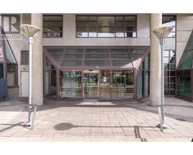 A building entrance with a glass door and two pillars on either side.
