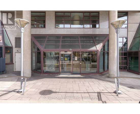 A building entrance with a glass door and two pillars on either side.