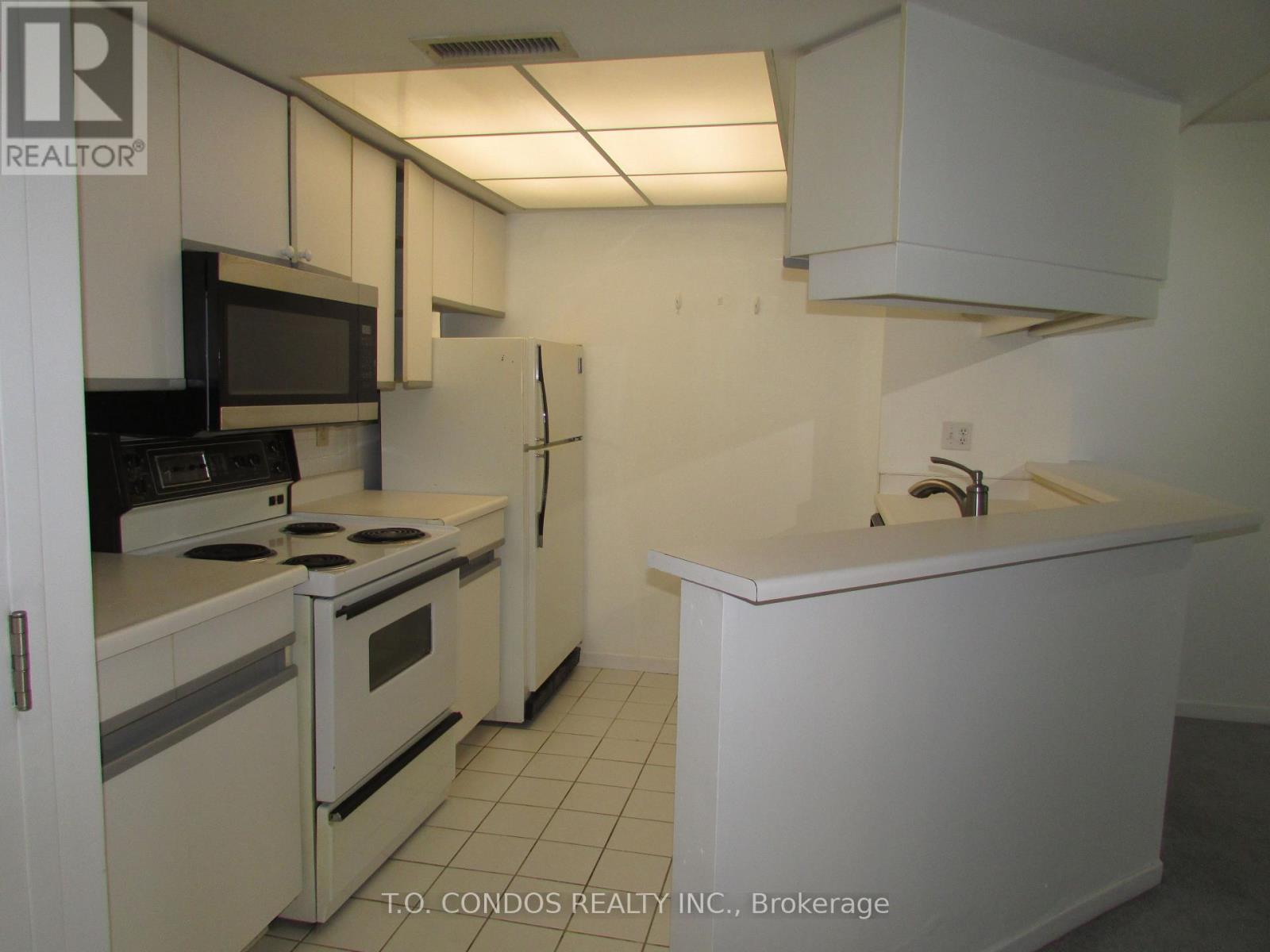 A white kitchen with a black stove top oven.