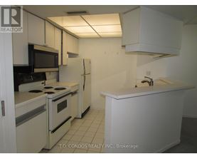 A white kitchen with a black stove top oven.