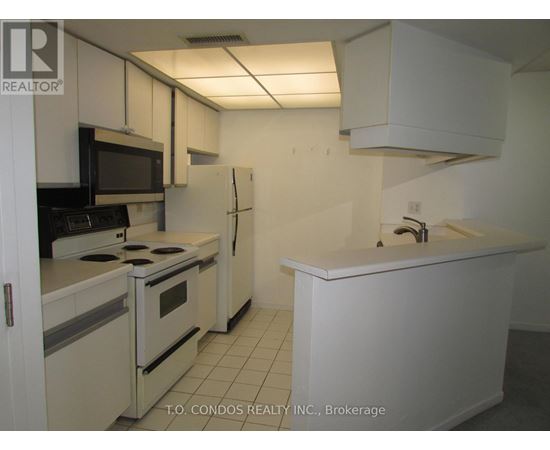 A white kitchen with a black stove top oven.