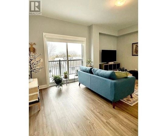 A blue couch sits in a living room with a television and sliding glass doors.