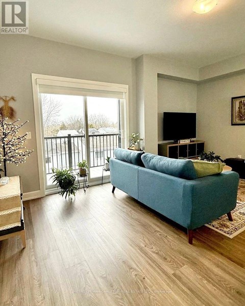 A blue couch sits in a living room with a television and sliding glass doors.