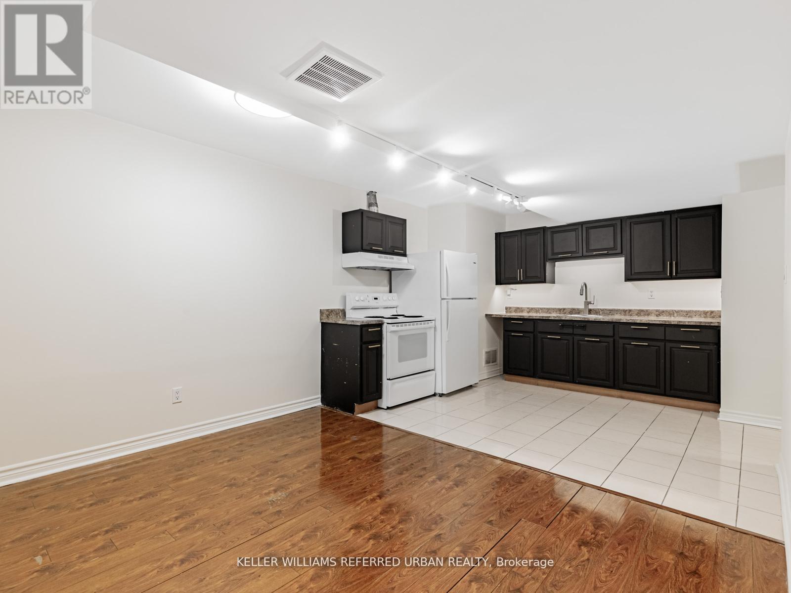 A kitchen with black cabinets and white appliances.