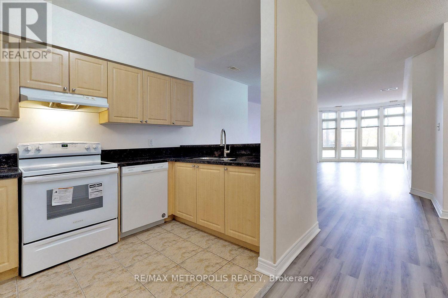 A kitchen with white appliances and wooden cabinets.