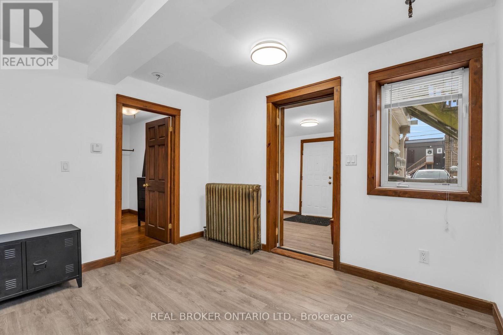 A realtor photo of a room with wood floors and white walls.