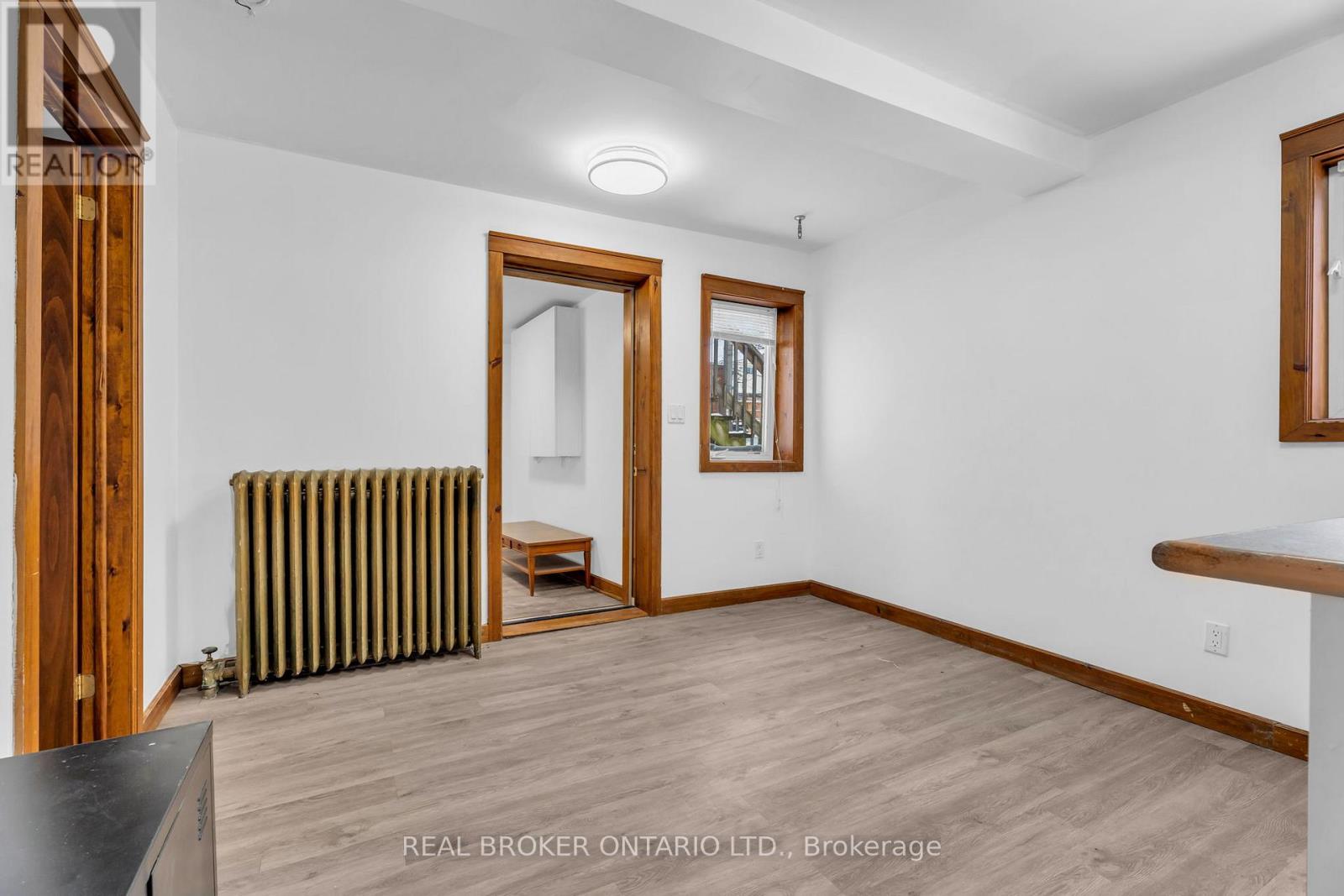A room with wood flooring and a radiator on the wall.