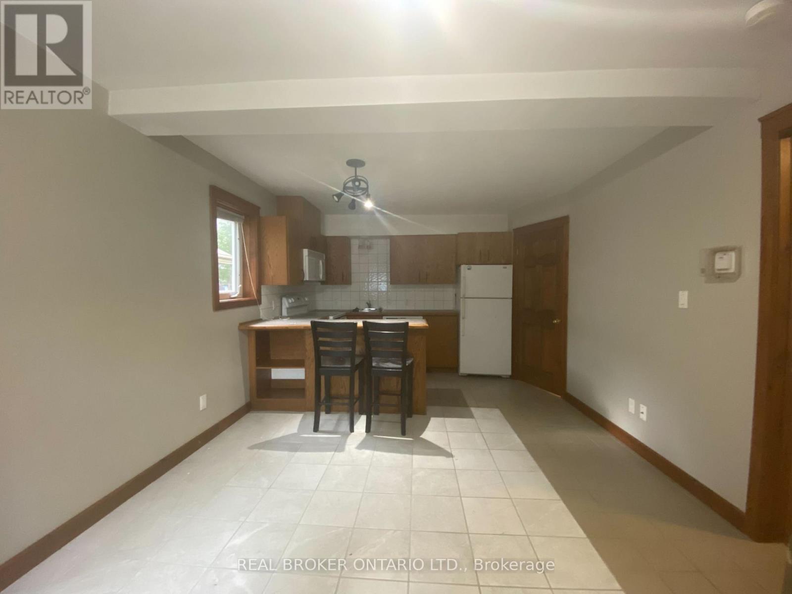 A realtor photo of a white kitchen with wood floors and white cabinets.