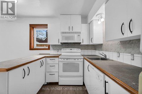 A white kitchen with a wood grain counter top.