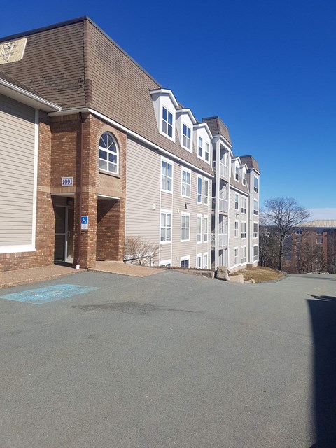A large building with a parking lot in front.