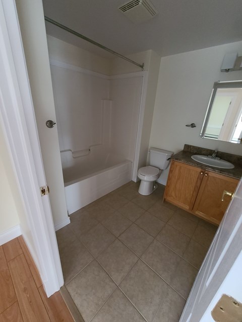 A bathroom with a toilet, sink, and bathtub.