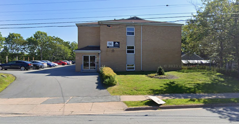 A building with the number 56 on it is surrounded by a parking lot.
