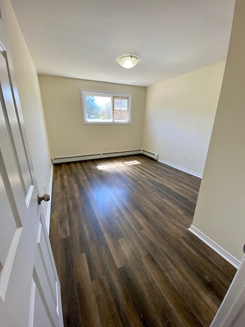 A room with wooden floors and a window.