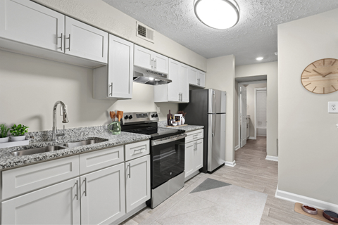 A kitchen with white cabinets and appliances.