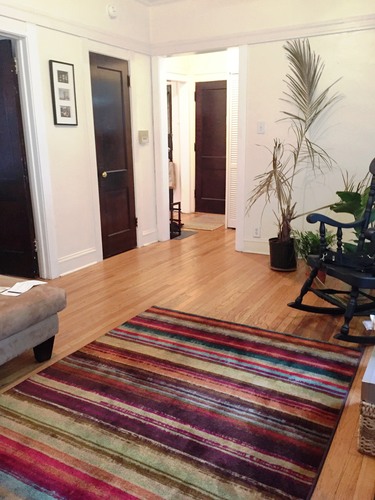 A room with a striped rug on the floor.