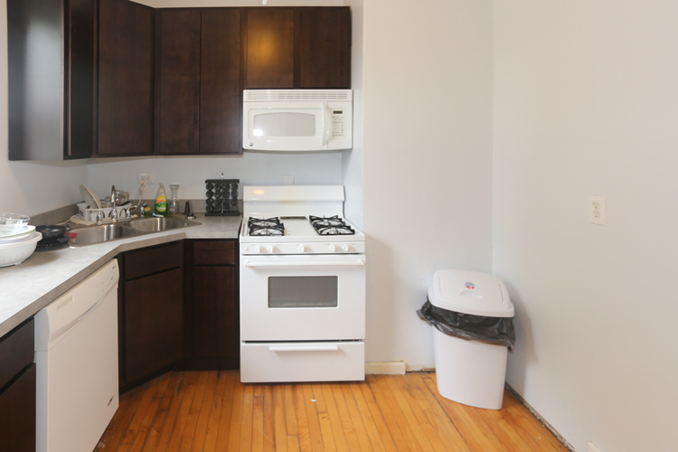 A white stove and oven in a kitchen with wooden floors.