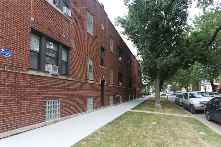 A red brick building with a white walkway in front.