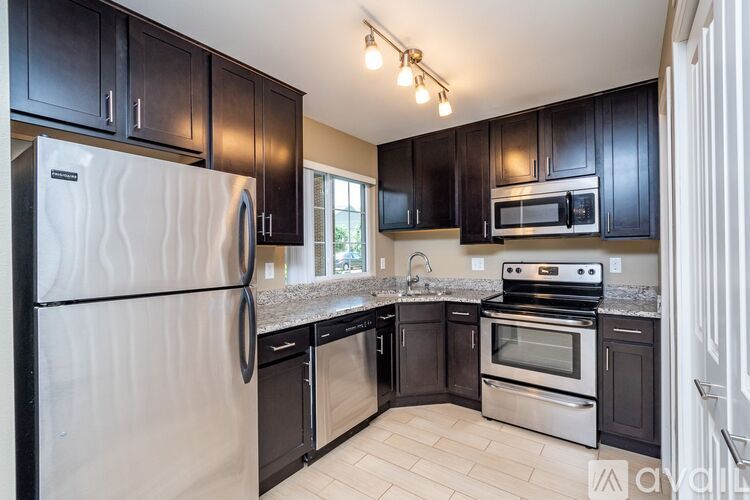 A kitchen with black cabinets and stainless steel appliances.