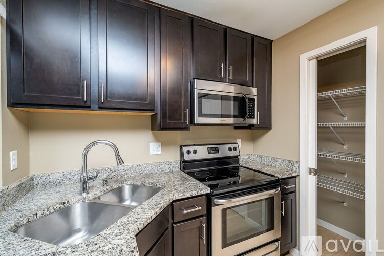 A kitchen with black cabinets and a granite countertop.