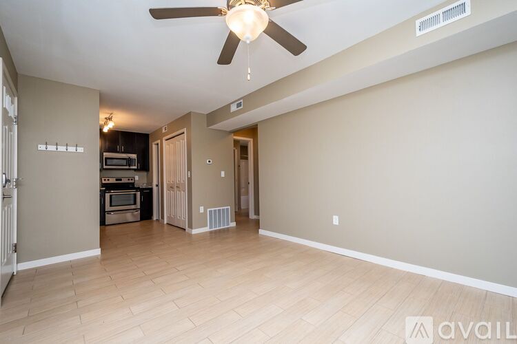 A spacious living room with a ceiling fan and light fixture.