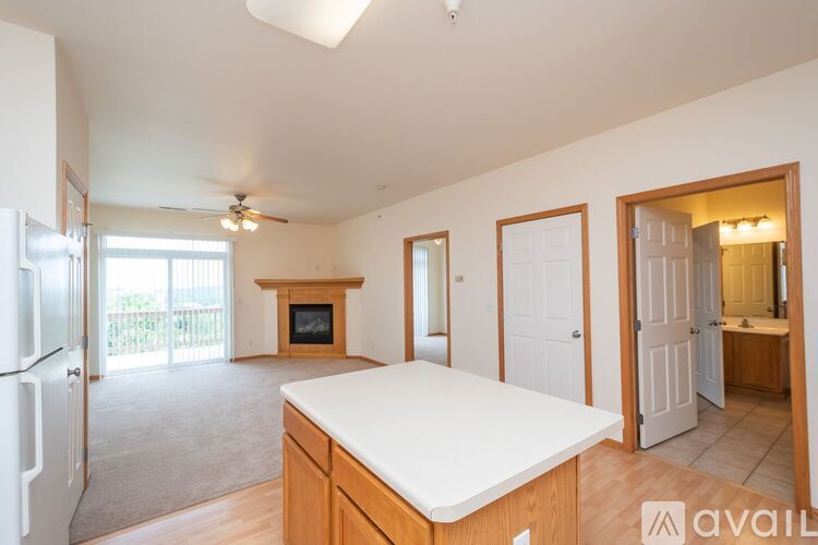 A kitchen with a refrigerator, a counter, and a television.