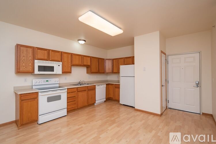 A kitchen with wooden cabinets and white appliances.