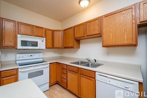 A kitchen with wooden cabinets and white appliances.