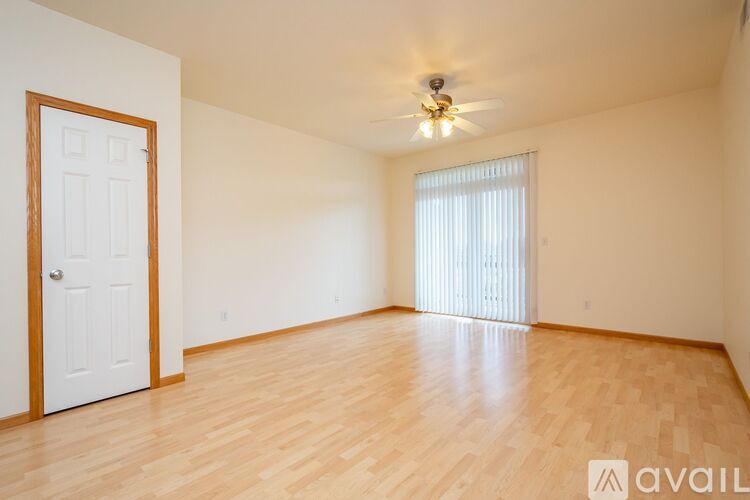 A room with wooden flooring and a ceiling fan.
