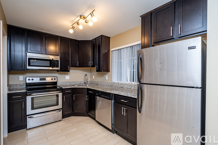 A kitchen with black cabinets and stainless steel appliances.