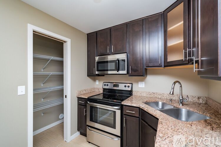 A kitchen with a sink, stove, and microwave.