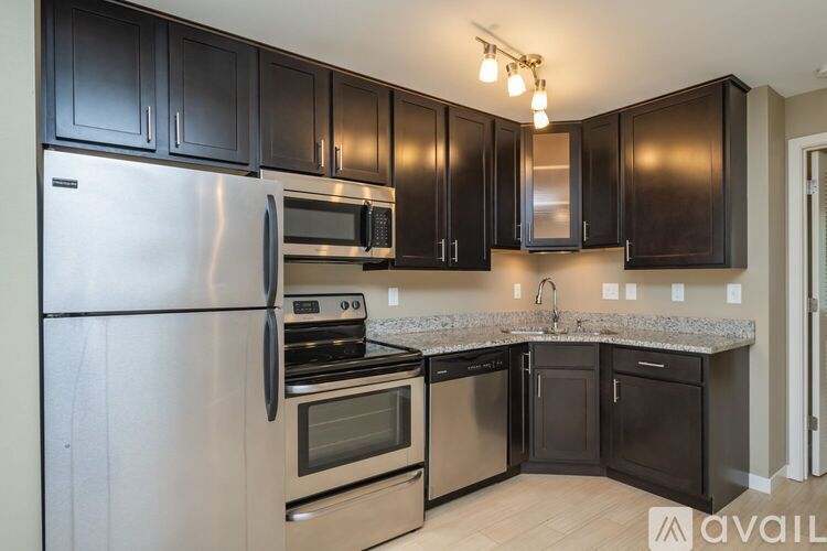 A kitchen with black cabinets and stainless steel appliances.