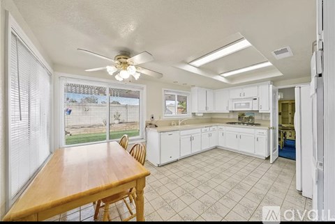 A kitchen with white cabinets and a wooden table.