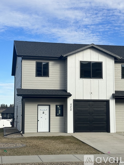 A two-story house with a garage door and a white door.